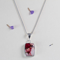 Handcrafted sterling silver pendant necklace with rectangular red and pink dahlia jasper stone, set in a serrated bezel on a delicate chain for a bold floral-inspired look.