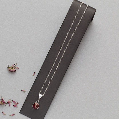 Full view of Dainty handmade sterling silver pendant necklace with round red and pink dahlia jasper stone, set on a fine chain with minimalist floral design and artisan elegance.