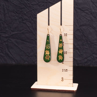 Green enamel teardrop earrings with 24k gold maple leaf design and 14k gold-filled ear wires, handcrafted nature-inspired jewelry.