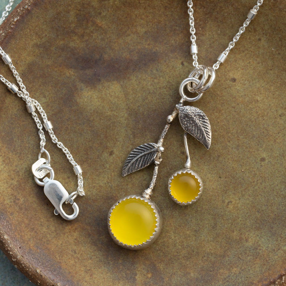 Yellow chalcedony and sterling silver Lemon Drop necklace with textured silver leaves on a rustic ceramic background.