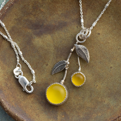 Yellow chalcedony and sterling silver Lemon Drop necklace with textured silver leaves on a rustic ceramic background.