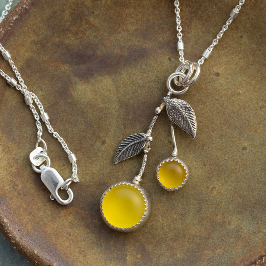 Yellow chalcedony and sterling silver Lemon Drop necklace with textured silver leaves on a rustic ceramic background.