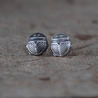 Tiny sterling silver beetle stud earrings by Divella Designs, 8mm size with patinated satin finish, handmade in Vermont and photographed on bark with lichen and dried flowers