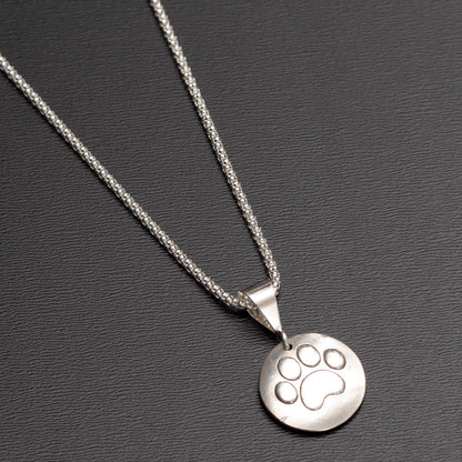 Paw print side of sterling silver reversible pendant necklace with paw print and tree of life designs on 18-inch chain.