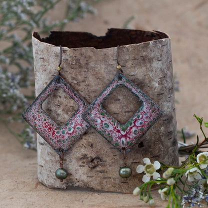 Handmade enamel earrings with red, green, and white floral pattern – diamond-shaped dangle earrings with open center and green pearl accent, artisan jewelry by Divella Designs.