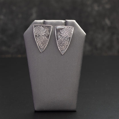 Sterling silver chrysanthemum earrings with etched floral design, handmade botanical jewelry with oxidized finish and modern triangular shape.
