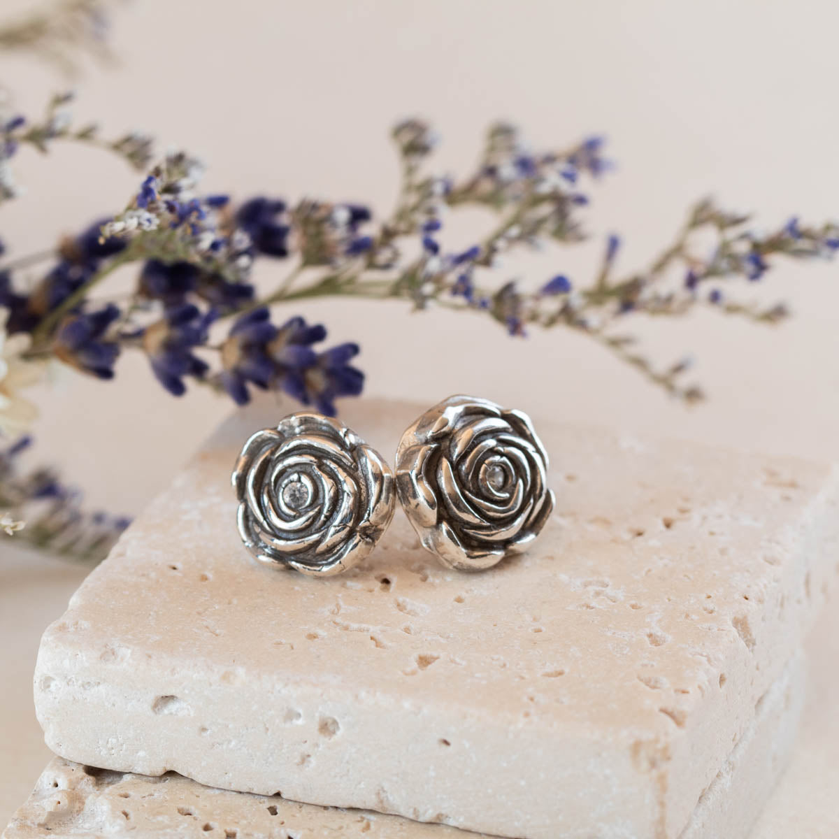 Handcrafted sterling silver rose stud earrings with dimensional sculpted petals, featuring romantic floral design and artisan botanical style