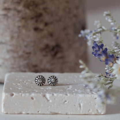 Tiny handmade sterling silver stud earrings with oxidized floral sunburst design, featuring 5mm round shape and minimalist vintage-inspired style.