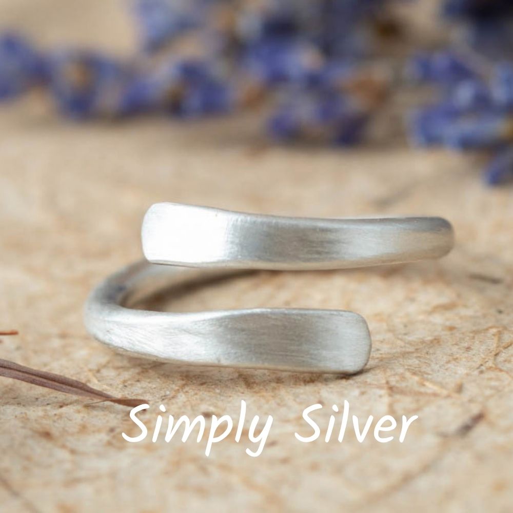 Silver wrap-around ring on a wooden surface with 'Simply Silver' branding.