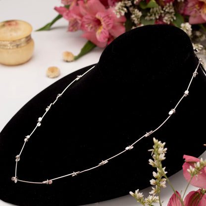 Side view of sterling silver necklace with handcrafted paddle links and blossom-like accents – modern artisan jewelry