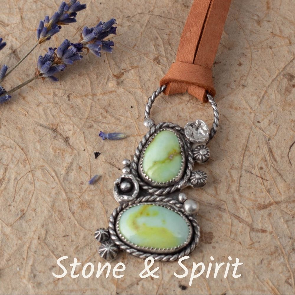 Pendant necklace with green stones and silver accents on a brown leather strap, with 'Stone & Spirit' branding.