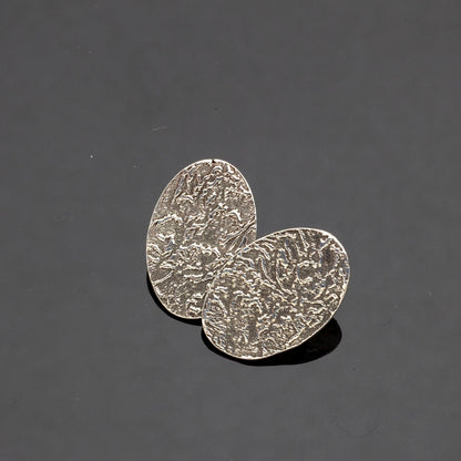 Handmade fine silver oval stud earrings with embossed organic texture, featuring earthy artisan style and oxidized finish for a nature-inspired look