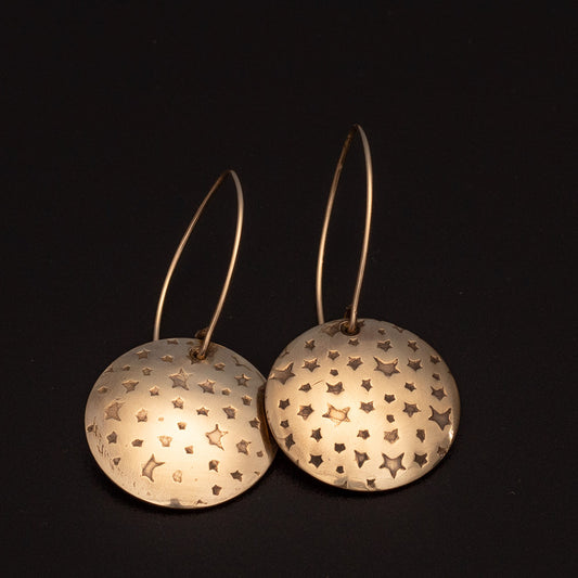 Brass star earrings with impressed celestial texture, 14k gold-filled ear wires, and 1 1/4 inch length, handmade by Divella Designs in Vermont.