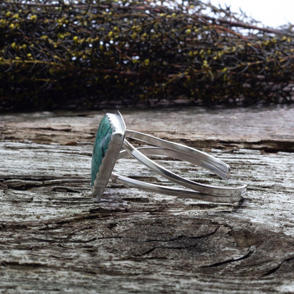 Side view of sterling silver cuff bracelet with triangular chrysocolla stone, fine silver bezel, artisan made in Vermont.
