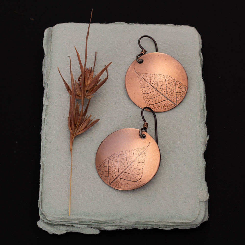 Copper leaf print earrings with round copper discs, botanical leaf detail, niobium ear wires, and 1 1/2 inch length, handmade by Divella Designs in Vermont.