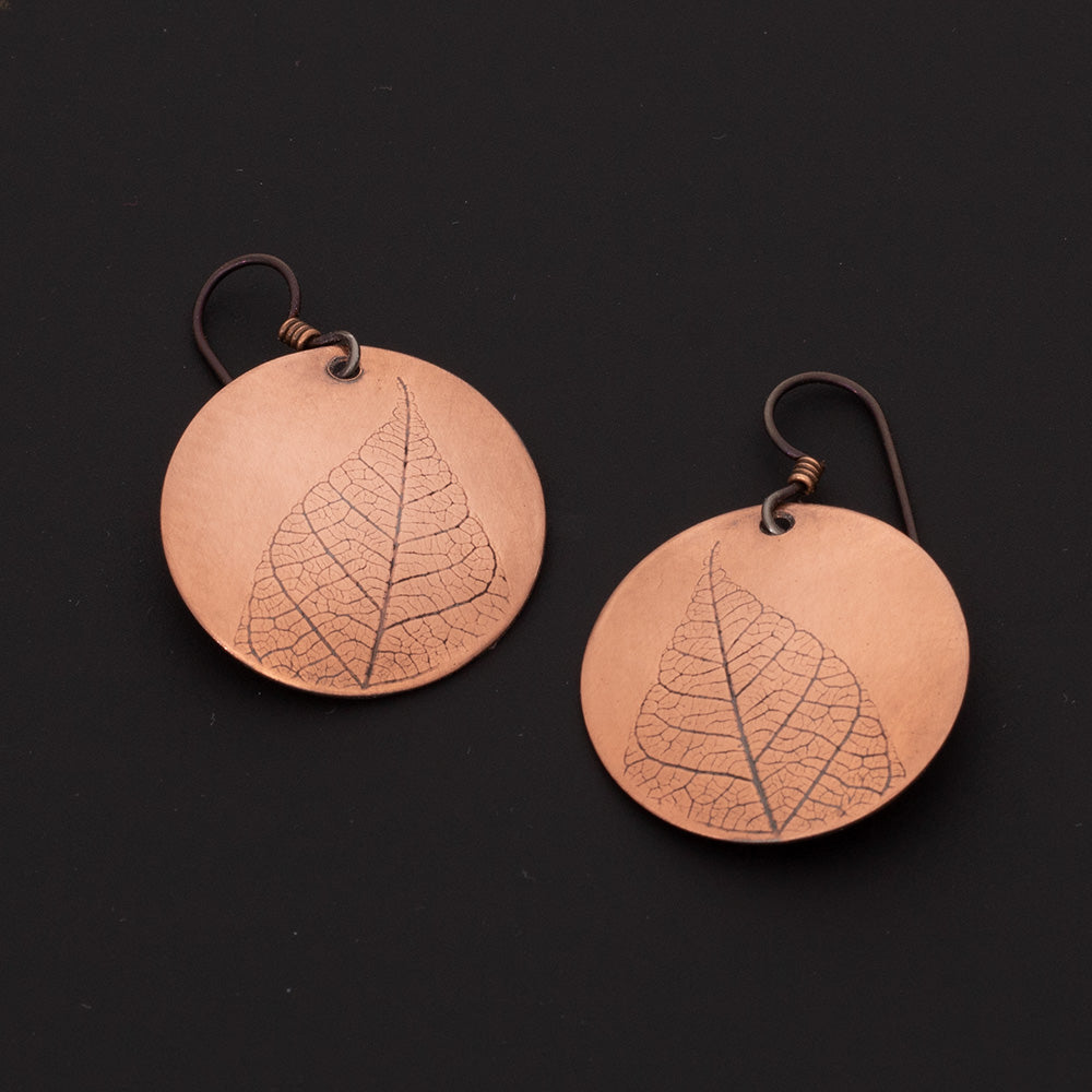 Copper leaf print earrings with round copper discs, botanical leaf detail, niobium ear wires, and 1 1/2 inch length, handmade by Divella Designs in Vermont.
