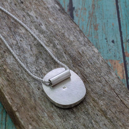 Back view of the Boreal Bloom Pendant  on weathered wood.