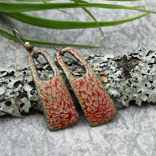 Red and green enamel earrings with organic lichen-inspired pattern and niobium ear wires