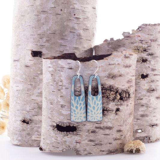 Handmade enamel earrings with pale blue botanical pattern, rectangle drop shape, sterling silver ear wires.