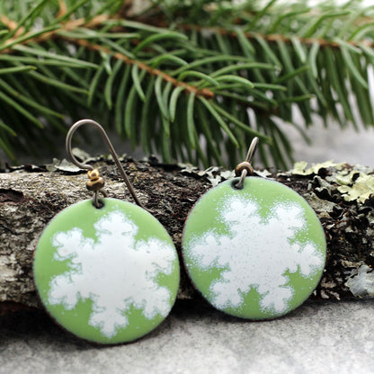Green enamel earrings with white snowflake design and niobium ear wires