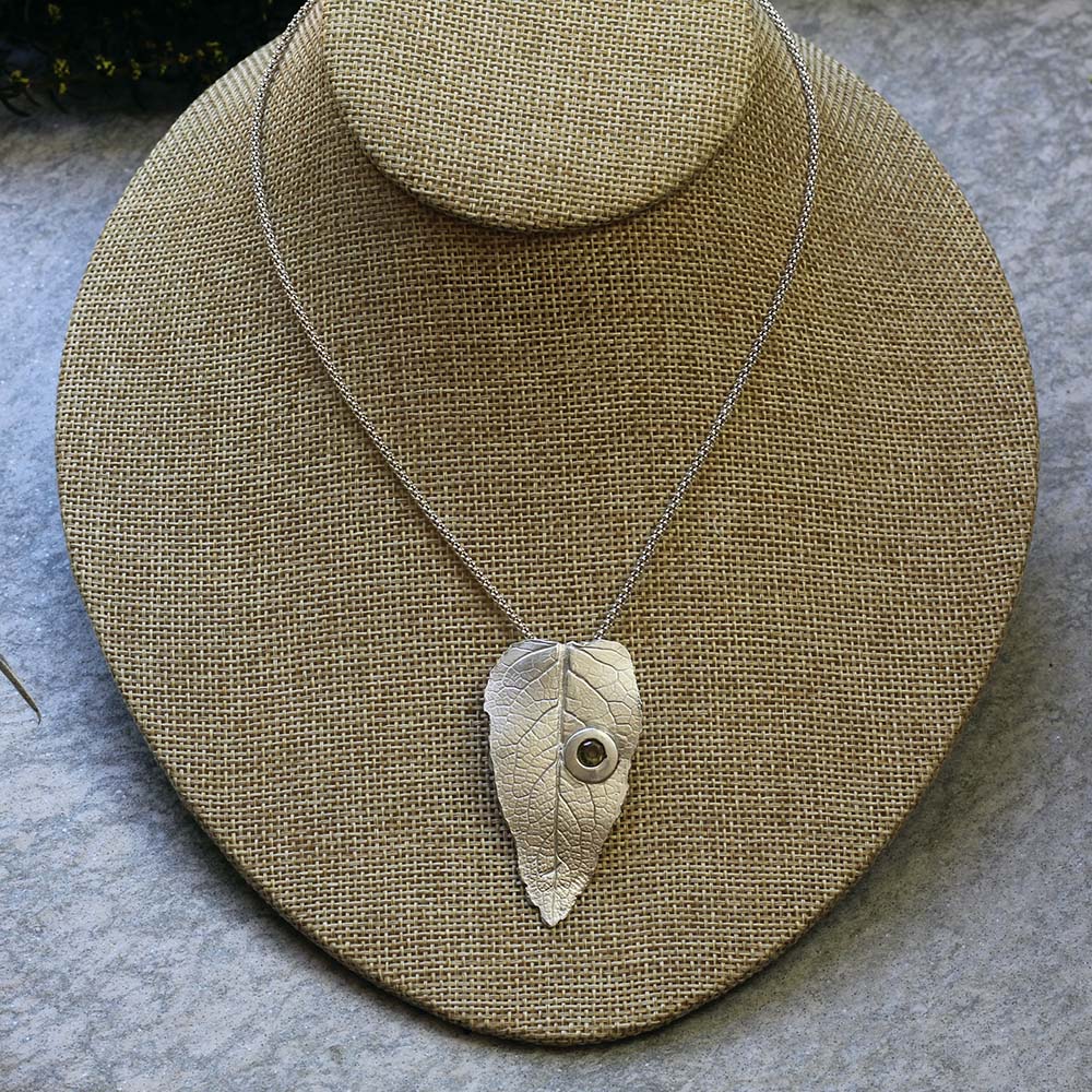 Sterling silver leaf pendant with gemstone detail on 20-inch chain