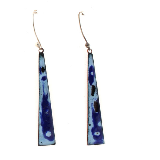 Long triangular copper earrings with a boho flair, featuring a rich blue and light blue enamel pattern with abstract dark spots, hanging from silver ear wires.