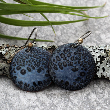 Black & Grey Opalescent Crackle Earrings on a lichen covered log with green plant in the background.