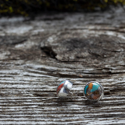 Sterling silver stud earrings with 10mm spiny turquoise stones in vibrant swirls of teal, coral, and rust, handcrafted with a serrated bezel setting.