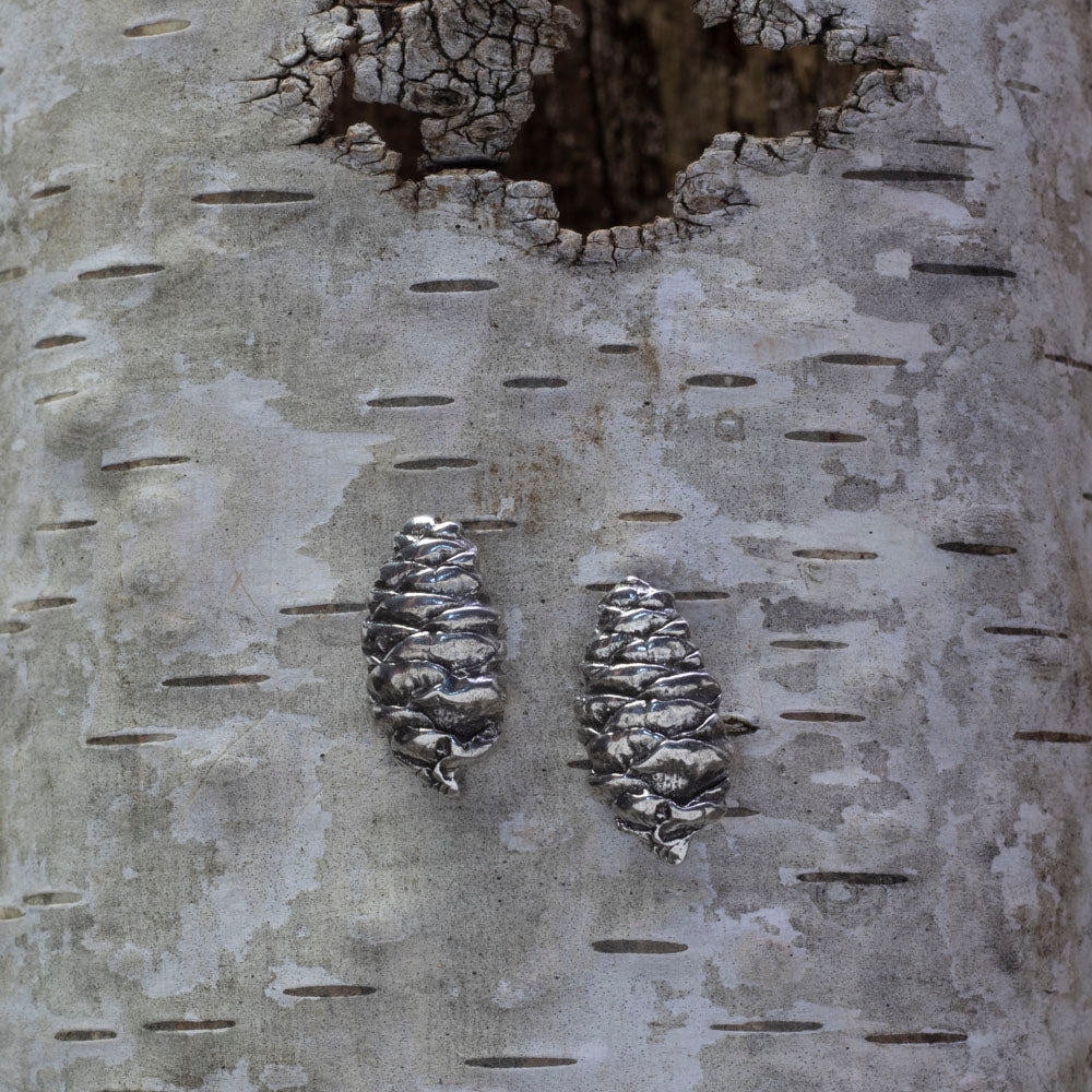 Sterling silver pinecone stud earrings with detailed texture, nature-inspired handmade jewelry