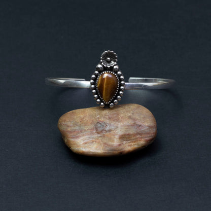 Sterling silver cuff bracelet with tiger’s eye cabochon in floral and beaded setting, handmade jewelry