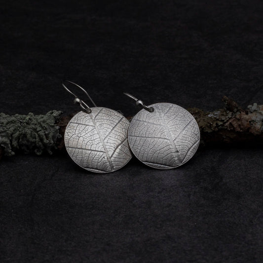 Sterling silver earrings with real leaf pattern and round disc shape
